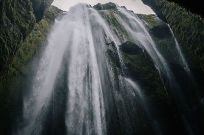 Low angle view of waterfall against clear sky