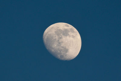 Low angle view of moon against clear blue sky