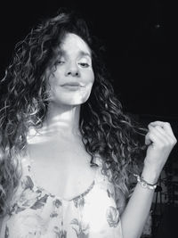 Portrait of woman against black background