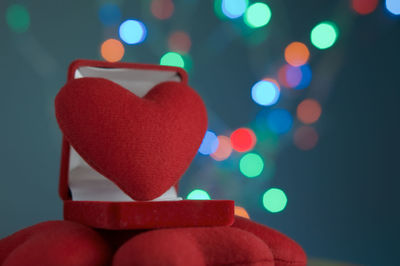 Close-up of heart shape in box against defocused multi colored lights