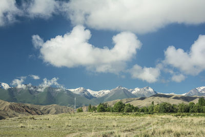 Scenic view of field and mountains against sky