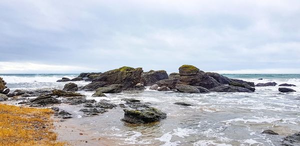 Rocks on beach against sky