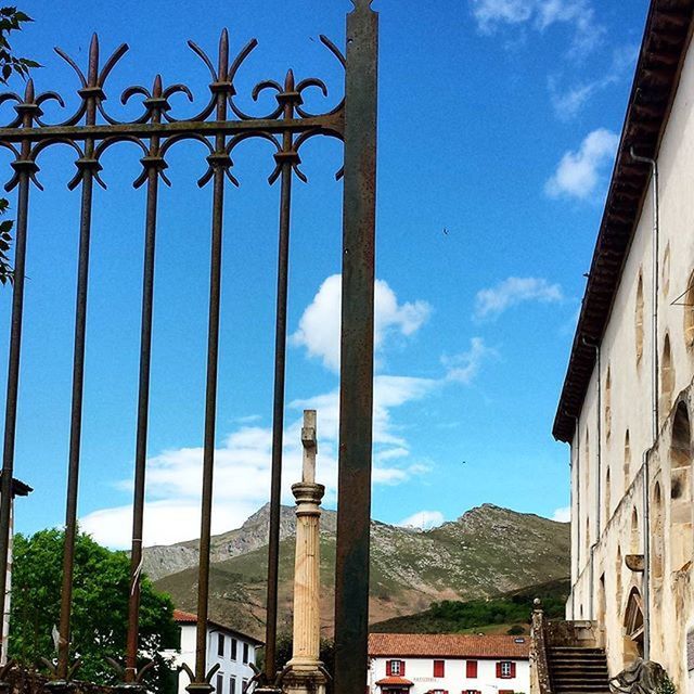 architecture, built structure, building exterior, sky, mountain, railing, blue, day, cloud, cloud - sky, mountain range, sunlight, no people, tree, famous place, outdoors, history, city, travel destinations, building