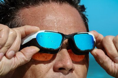 Close-up of man removing swimming goggles