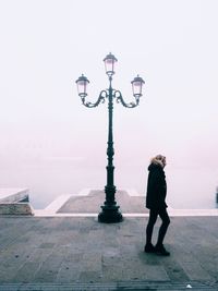 Woman with umbrella against sky