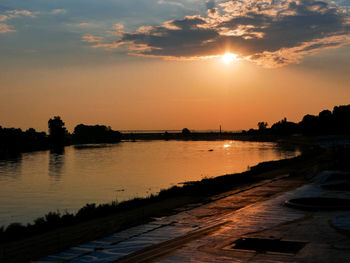 Scenic view of river against orange sky