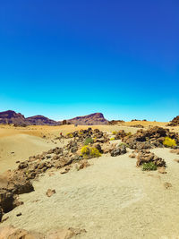 Scenic view of desert against clear blue sky