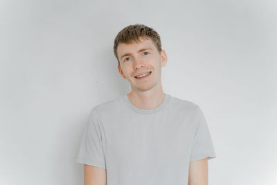 Portrait of young man standing against white background