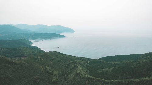 Scenic view of sea and mountains against sky