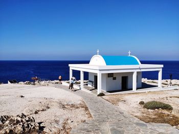 Lifeguard hut on beach against clear blue sky