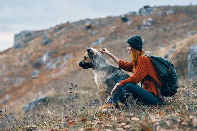 Woman sitting with dog on land