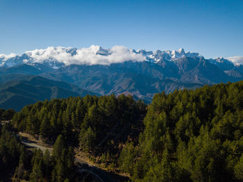 Scenic view of trees and mountains against sky
