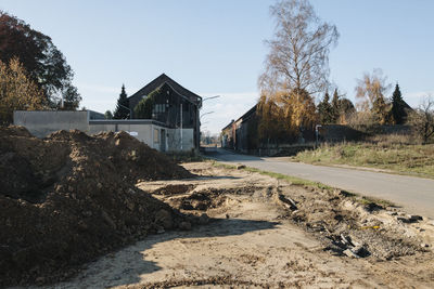 Abandoned building by road against clear sky