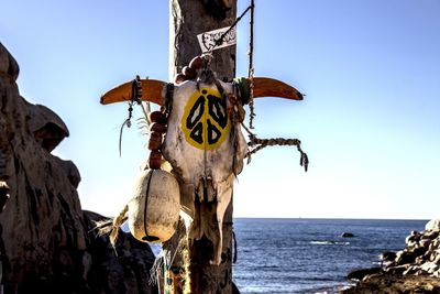 Panoramic shot of wooden post by sea against clear sky