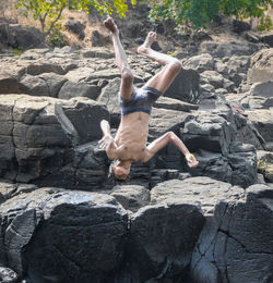 Full length of man jumping on rock