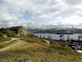 Scenic view of river by buildings against sky