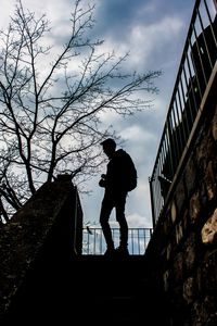 Low angle view of silhouette man standing against sky