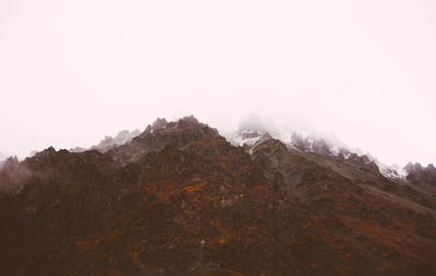 Low angle view of mountain against cloudy sky