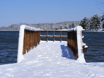 Snow covered wooden post against sky during winter