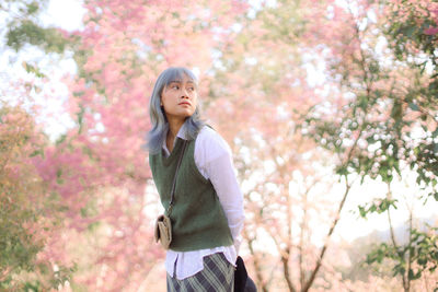 Full length of woman standing against cherry tree