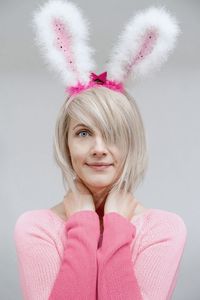 Portrait of smiling woman against pink background