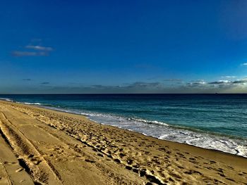 Scenic view of beach against blue sky