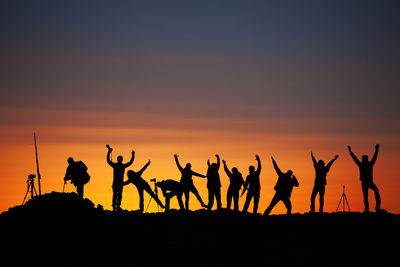 Silhouette people at sunset against sky