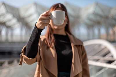 Midsection of woman drinking coffee