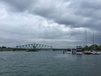 Bridge over river against cloudy sky