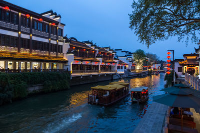 Canal amidst buildings against sky in city