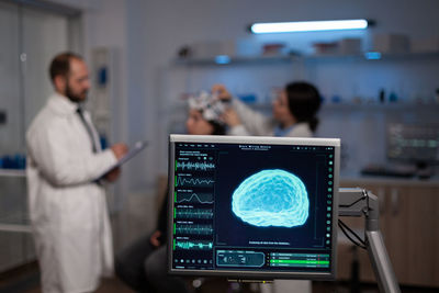 Side view of man using laptop at clinic