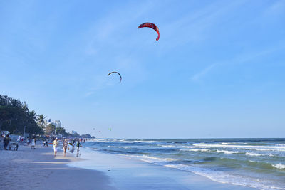 People at beach against sky