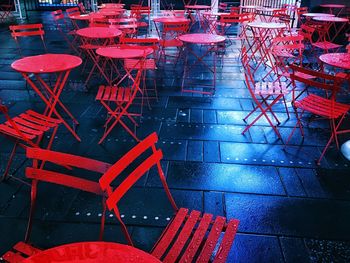 High angle view of empty chairs and tables at sidewalk cafe