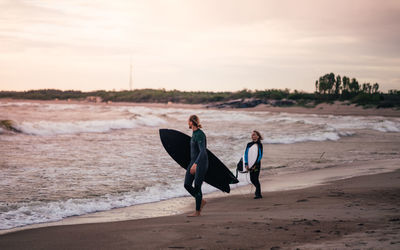People with surfboard walking at beach
