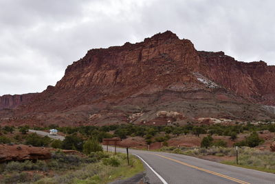 Road leading towards mountains against sky