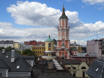 Buildings in city against cloudy sky