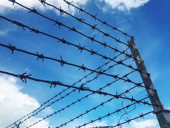 Low angle view of barbed wire against sky