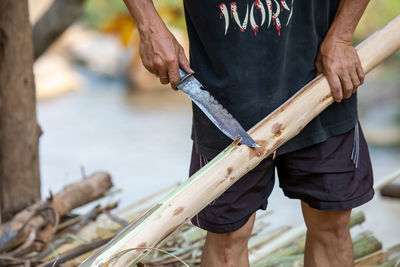 Low section of man standing on log