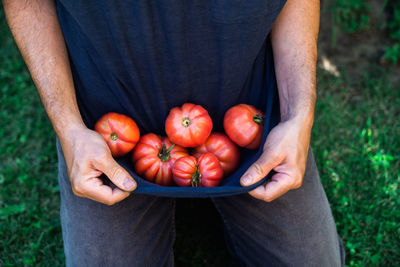 Midsection of man holding red berries