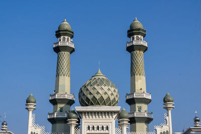 Low angle view of buildings against clear blue sky