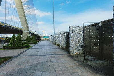 Footpath amidst buildings against sky