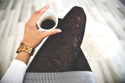 High angle view of hand holding coffee cup