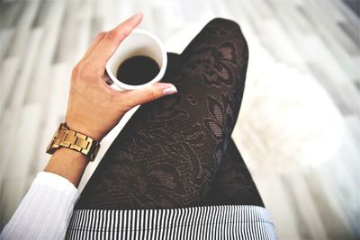 High angle view of hand holding coffee cup
