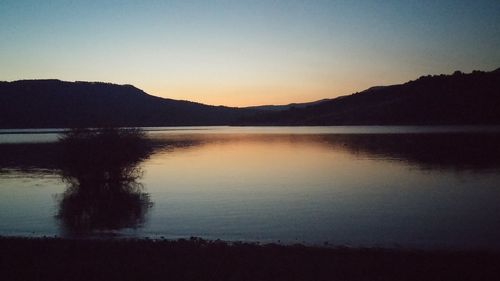 Scenic view of lake against sky at sunset