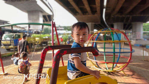 Portrait of boy playing in playground at amusement park