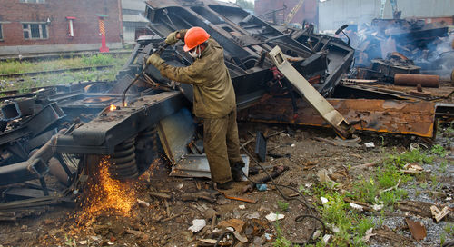 Worker welding scrap metal