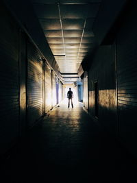 Rear view of silhouette man walking in tunnel