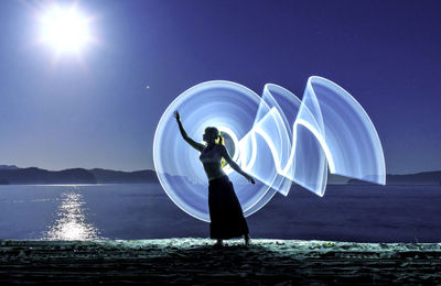 Rear view of man standing in sea against clear sky