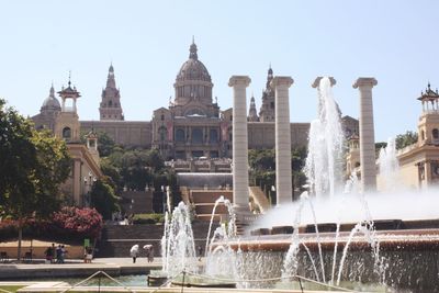 Fountain in front of museum against sky