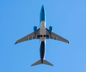 Low angle view of airplane against clear blue sky